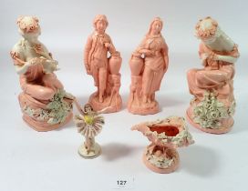 A pair of continental pink ceramic figures with white floral detailing, two similar pink figures