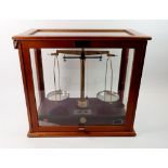 A Griffin & Tatlock set of balance scales in glazed case, 45cm wide