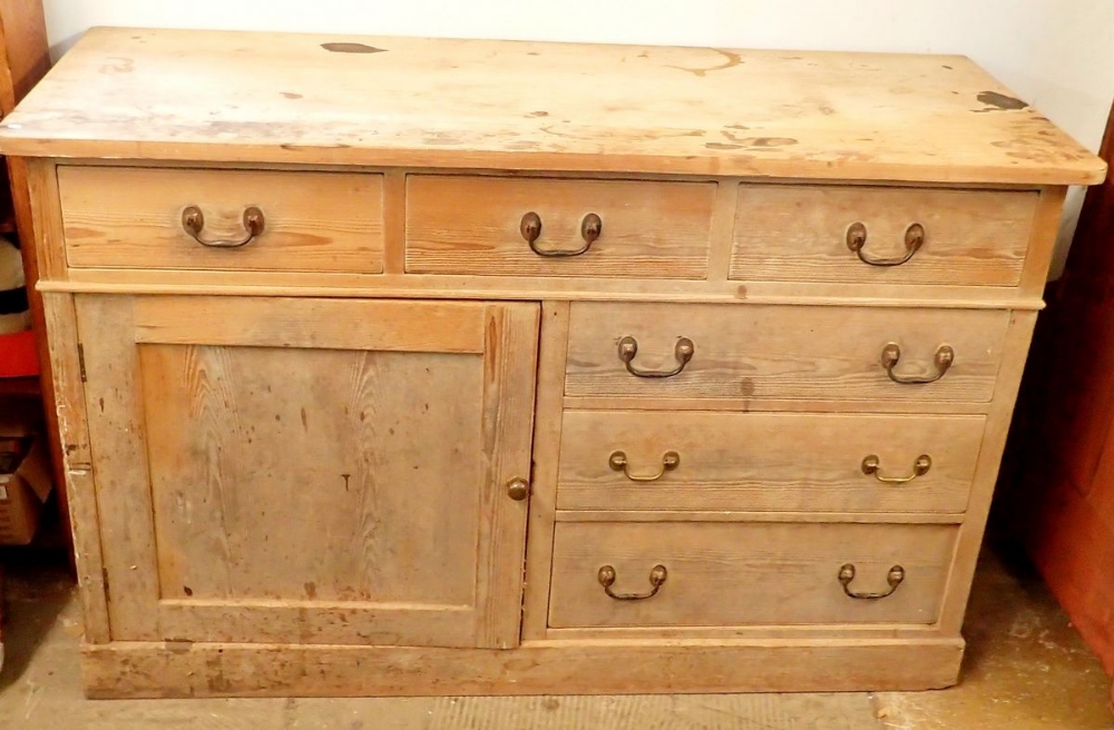 A 19th century pine side cabinet with three frieze drawers over cupboard and three further