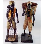 Two large African Indian decorative resin figures, man with monkey and cage and man with fruit