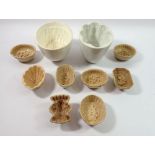 A collection of eight small brown pottery jelly moulds including asparagus, fruits etc and two