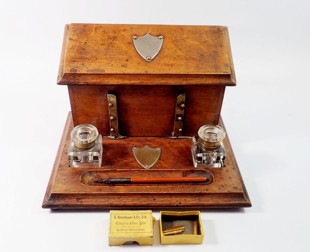 A Victorian oak correspondence box with rise top letter compartment and inkstand fitted two glass