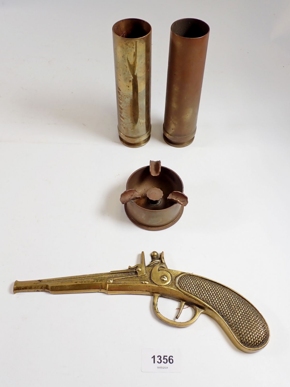 Two shell case vases and a trench art ashtray plus a gun wall ornament