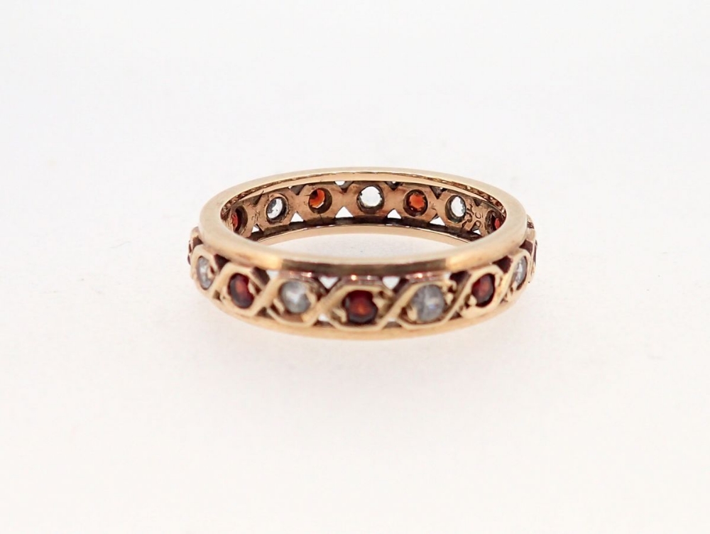 A 9 carat gold garnet and white stone eternity ring, size J to K, 2.2g - Image 2 of 3