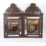 A pair of Flemish style patinated brass cushion framed mirrors, 59 x 33cm