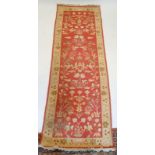 A Turkish style runner with floral design on coral ground, 271 x 93cm