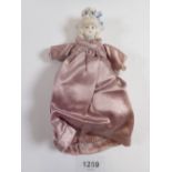 A Victorian 'bonnet head' doll with bisque head and hands and fabric body, 14cm