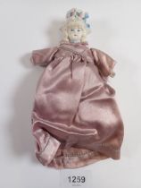 A Victorian 'bonnet head' doll with bisque head and hands and fabric body, 14cm