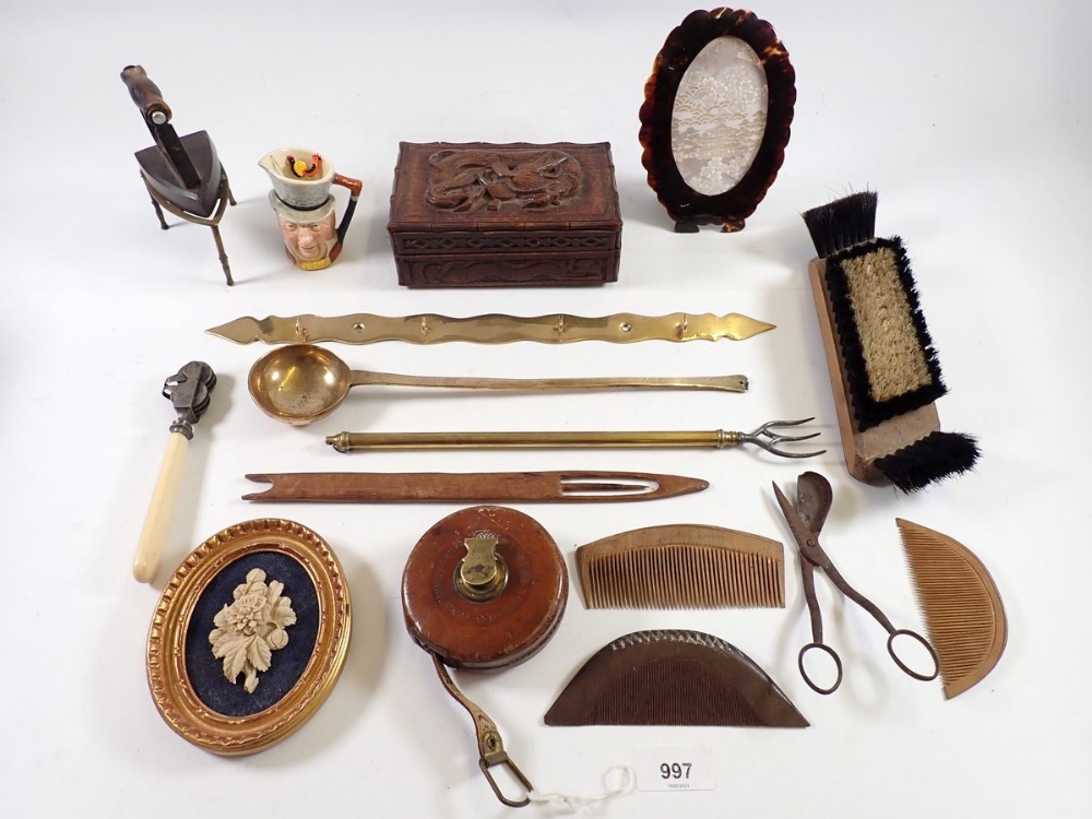 A box of collectables including tape measure, treen combs, carved box etc.