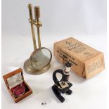 A brass magnifying glass on stand and a students microscope etc.