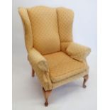 A wing armchair on cabriole supports