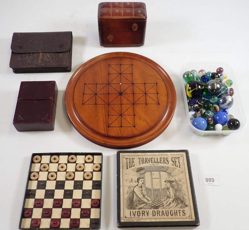 A Victorian boxed travellers set of simulated ivory draughts, a leather playing card box, games