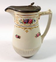 A Winton floral painted jug with pewter lid, 18cm tall