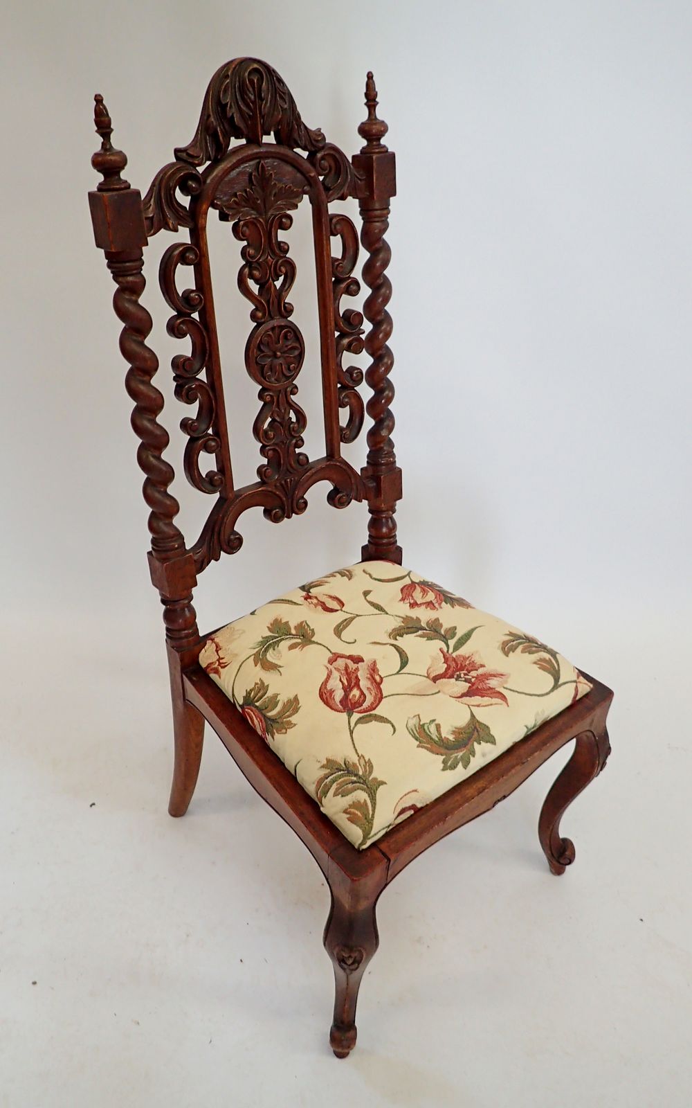 A Victorian small chair with ornately carved back