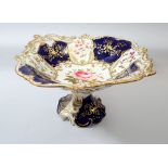 A large Victorian floral painted comport with blue and gilt reserves - a/f to base, 30cm wide