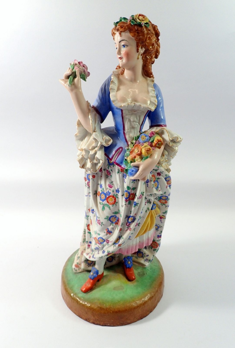 A 19th century French porcelain large figure of a woman with flowers, 44cm tall