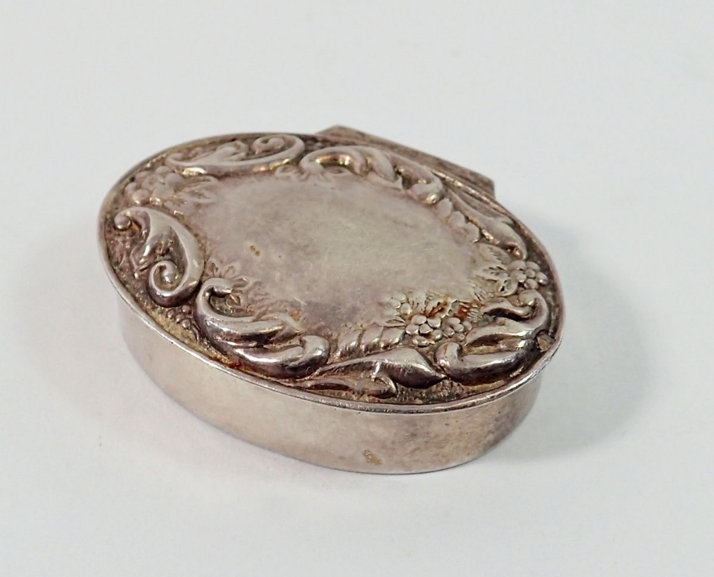 A modern silver oval pill box with embossed scrollwork decoration, 9g, 3 x 2.3cm
