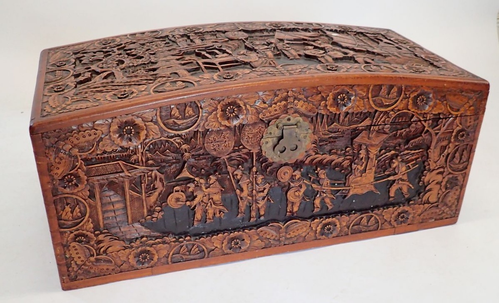 A Chinese camphorwood chest with dome top, carved oriental scenes, 90cm wide