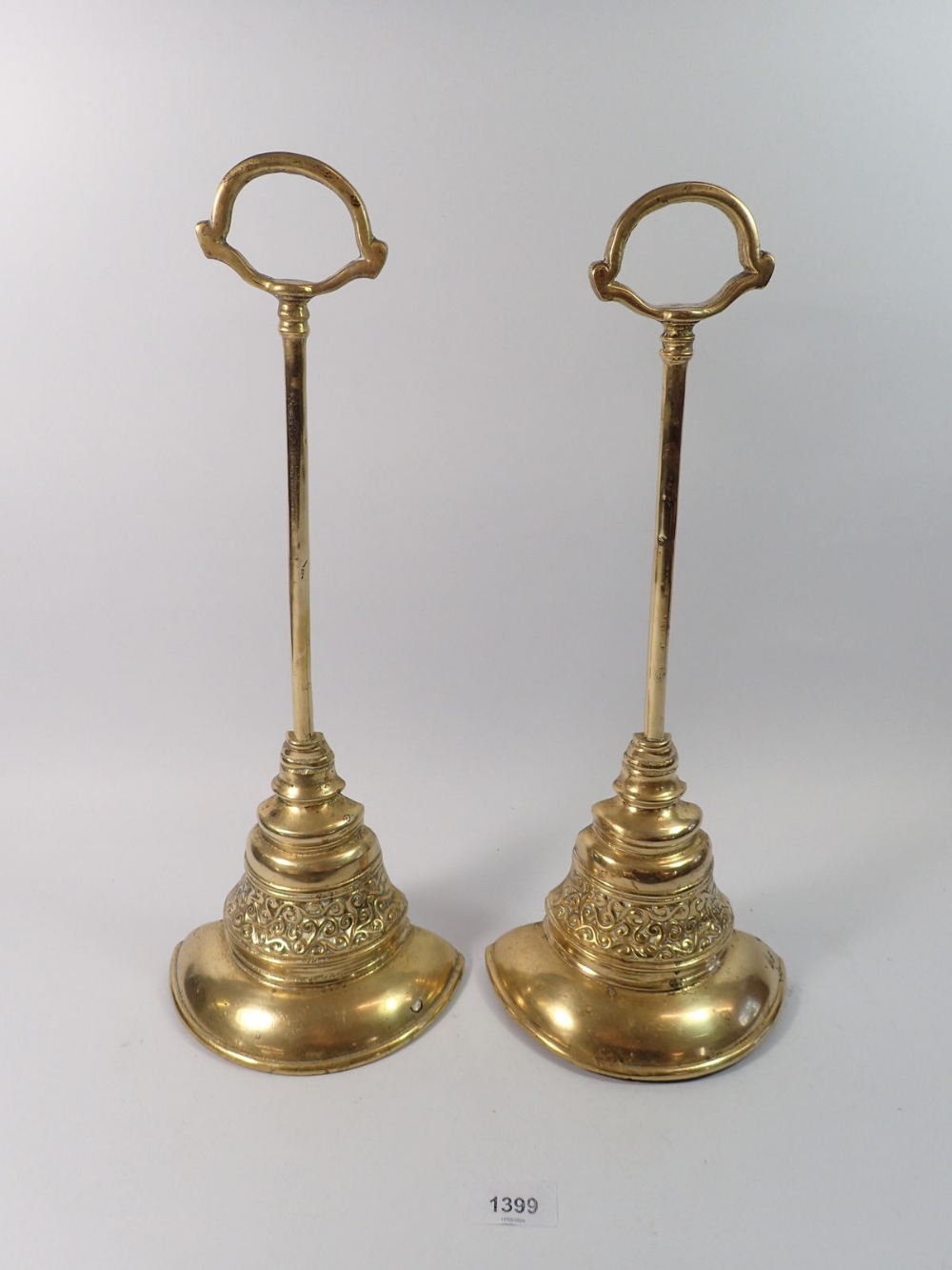 A pair of Georgian brass door stops or porters of bell form