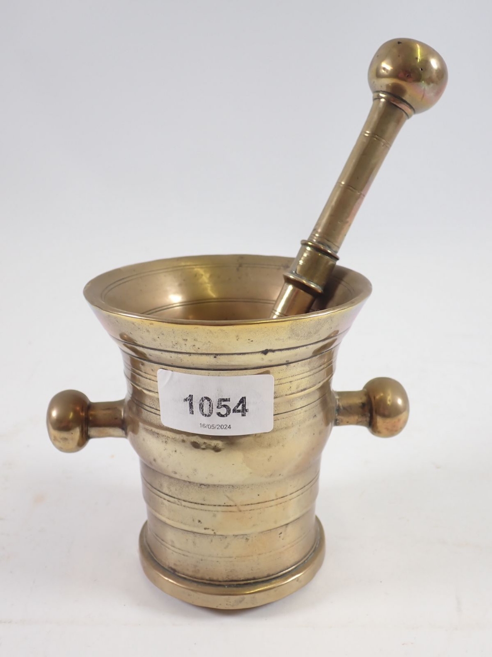 An antique brass pestle and mortar, 11cm tall