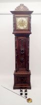 A 19th century continental oak cased longcase clock with square brass dial, the case ornately carved