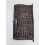 A carved Dogon tribal door, thought to be from a granary grain store in Mali, decorated three rows