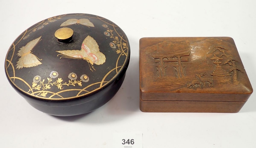 A Japanese circular black lacquer box painted butterflies, 17cm diameter and a carved wood