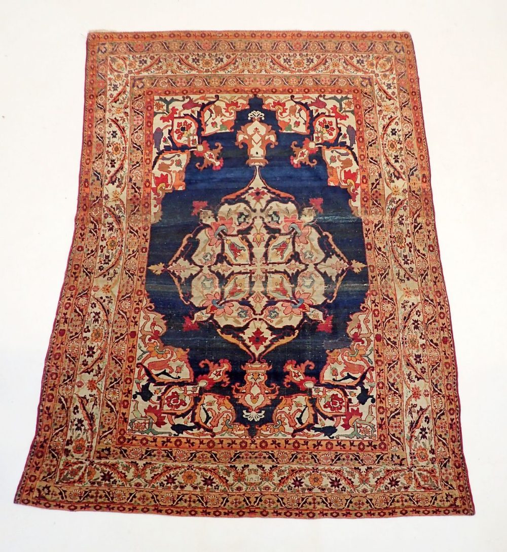 An antique silk Tabriz rug with large medallion on blue ground within multiple floral borders,