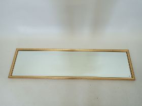 A full length gilt framed mirror, 34.5 x 124.5cm