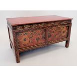 A small Chinese red painted wooden chest with floral decoration, secret door to reverse, 75 x 38 x