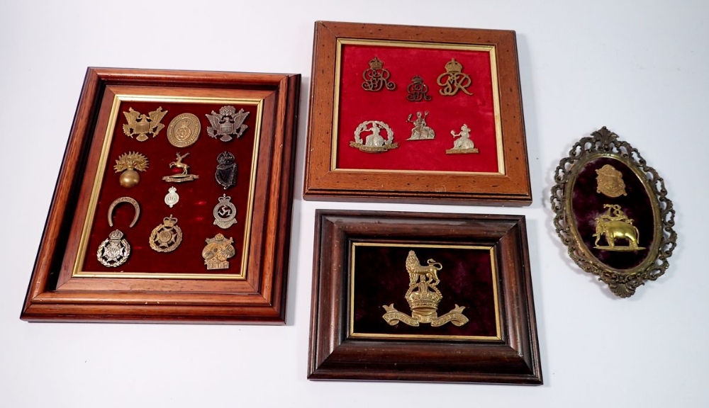 A framed display of ten Home Guard cap badges, a framed Royal Marines Helmet plate plus two other