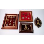 A framed display of ten Home Guard cap badges, a framed Royal Marines Helmet plate plus two other