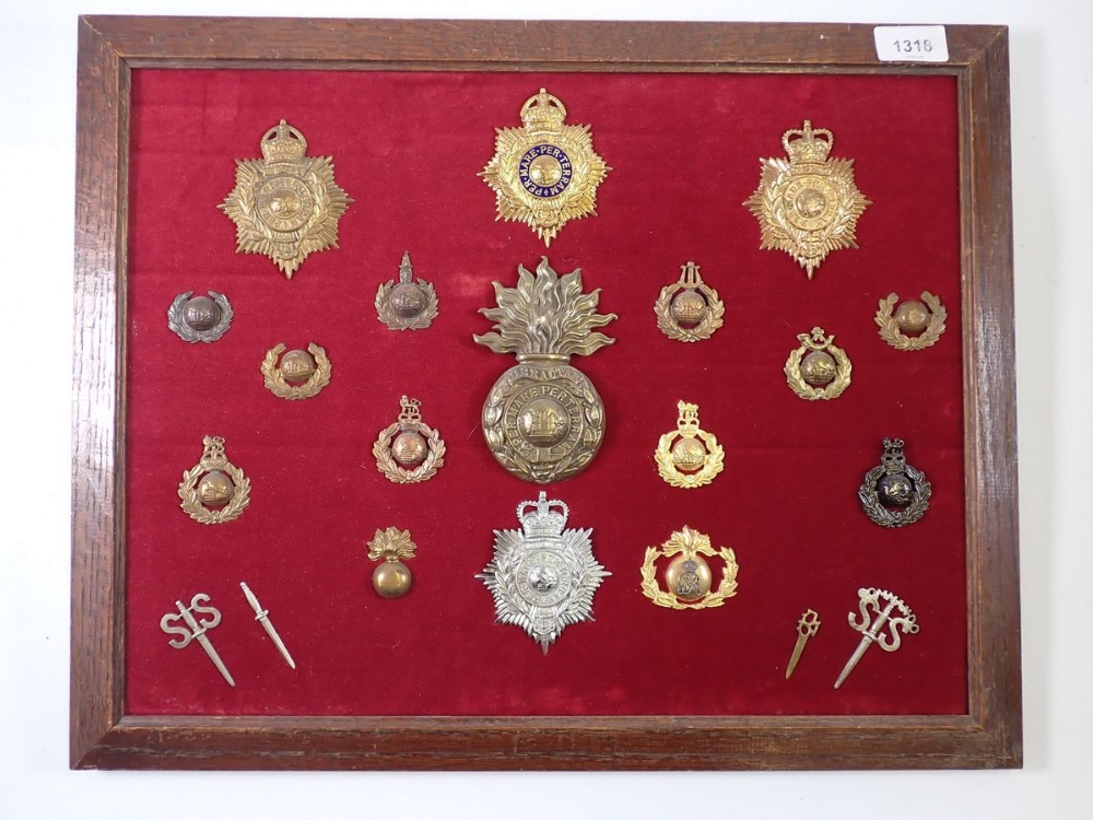 A framed display of twenty Special Forces military cap badges including Commando 55 badges and