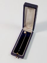 A 9ct gold stick pin set pearl, unmarked but tested as gold, cased, 1.3g