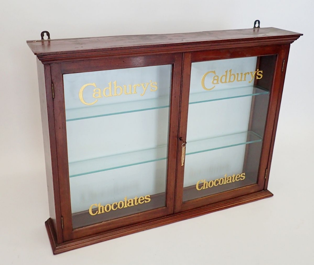 An Edwardian mahogany two door glazed Cadbury's Chocolate shop display cabinet with glass doors