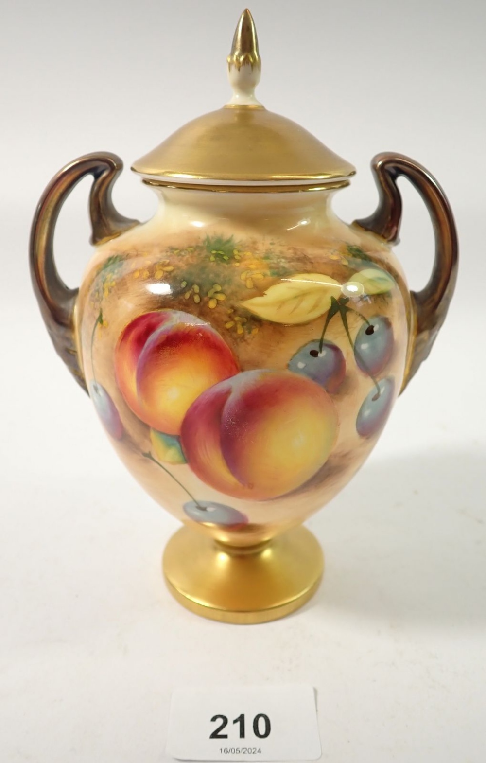 A Royal Worcester two handled urn form vase and cover painted fruit by Roberts, 17cm tall