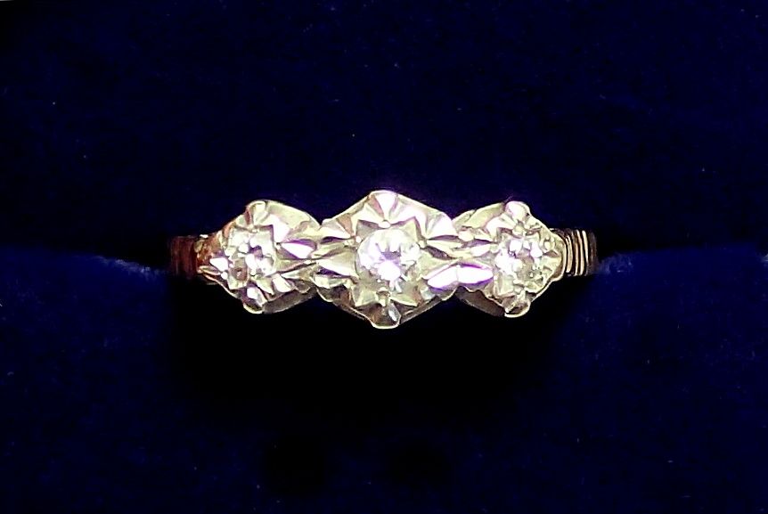 A 9 carat gold illusion set three stone diamond ring, size L to M, 2.2g