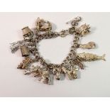 A white metal charm bracelet with white metal and silver charms, 69g