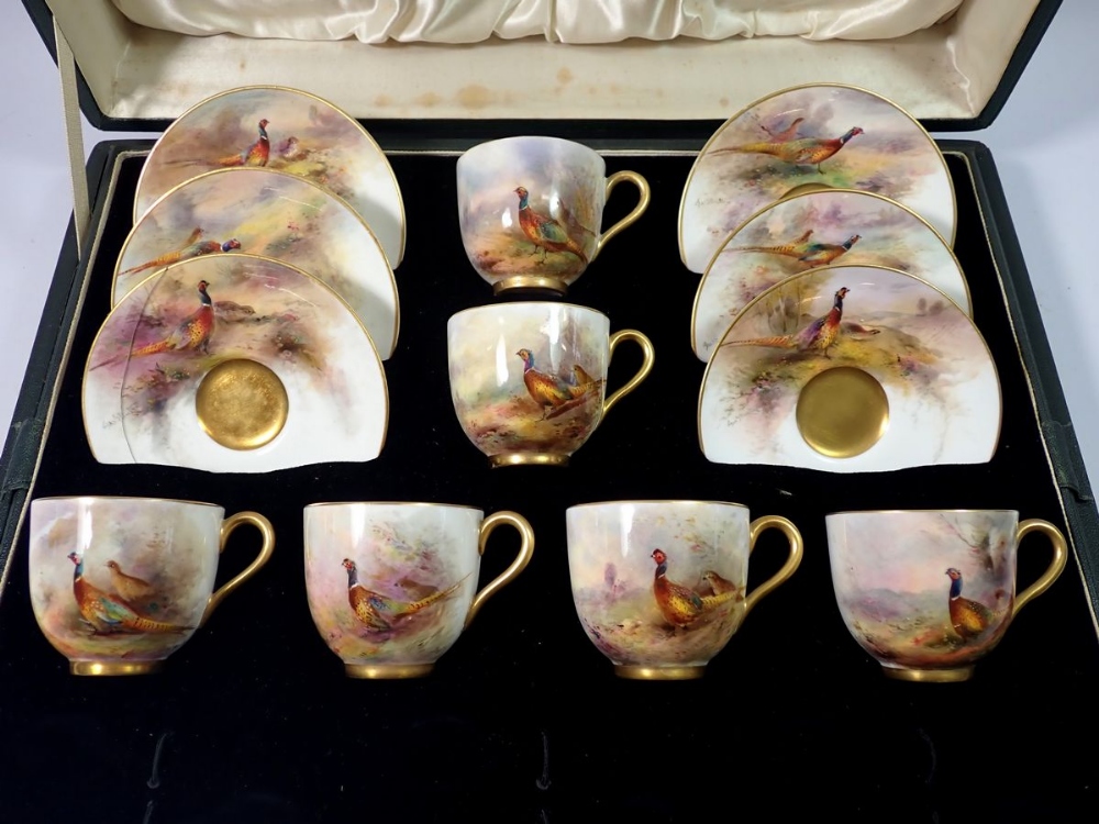 A set of six Royal Worcester coffee cans and saucers painted pheasants by James Stinton in a