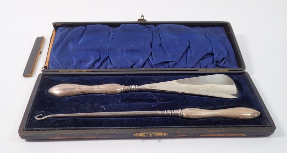 A silver handled shoe horn and button hook - cased