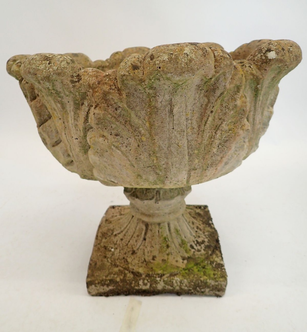 A reconstituted stone garden urn with foliage decoration 43cm tall