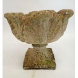 A reconstituted stone garden urn with foliage decoration 43cm tall