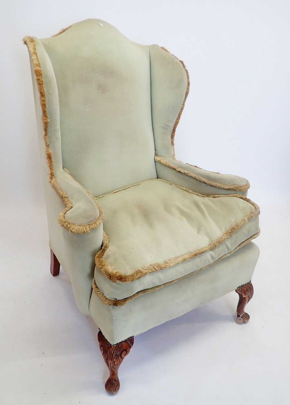 An early 20th century wing armchair on carved cabriole supports