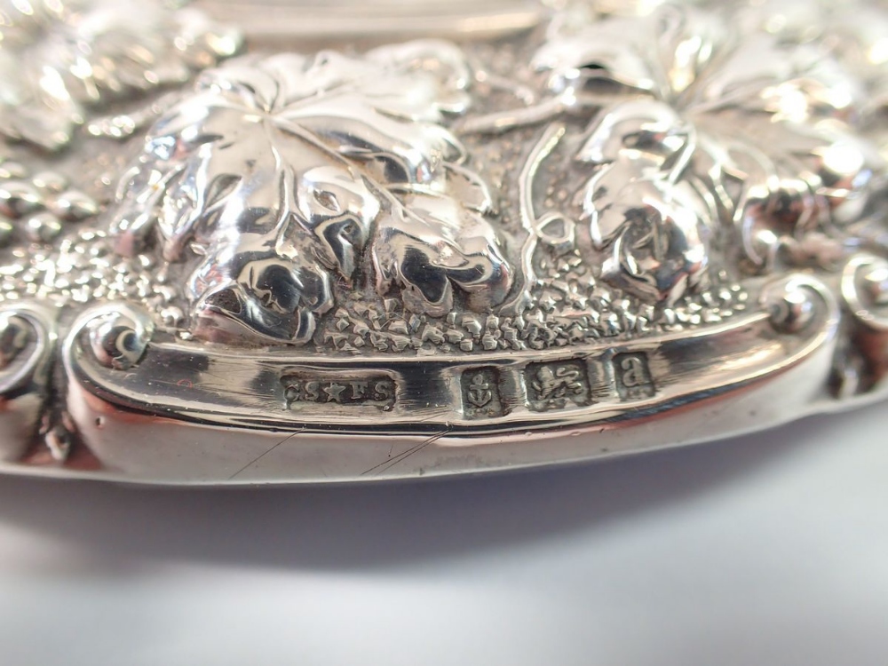 A Victorian silver backed mirror decorated vines and three silver backed brushes - Image 2 of 3