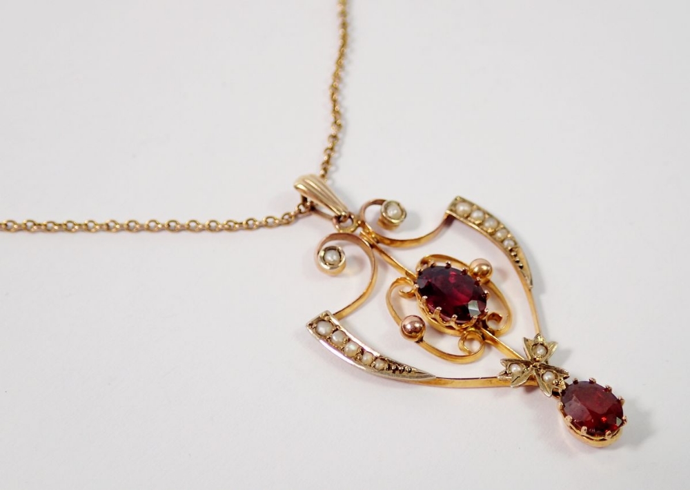 An Edwardian Art Nouveau openwork pendant set garnets and seed pearls, 4cm drop on 9 carat gold