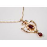 An Edwardian Art Nouveau openwork pendant set garnets and seed pearls, 4cm drop on 9 carat gold