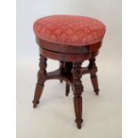 A Victorian mahogany revolving piano stool on reeded supports