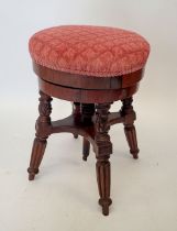 A Victorian mahogany revolving piano stool on reeded supports