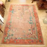 A Chinese large rug with dragons and flowers on dusty pink ground, 266 x 184cm