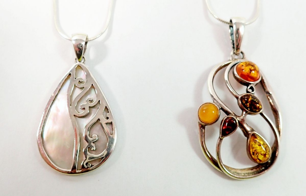 A silver and amber pendant and a silver and mother of pearl pendant on silver chain